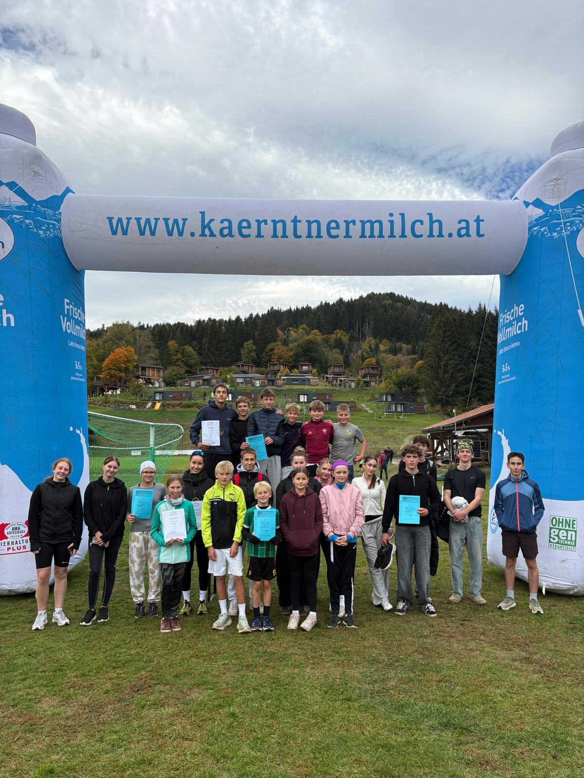 Jugendliche mit Urkunden vor einem Torbogen mit www.kaerntnermilch.at in Kärnten